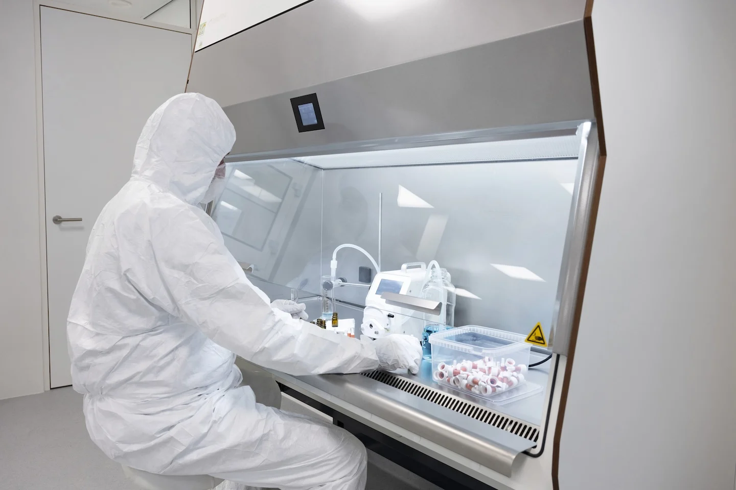 Pharmacist working in isolator with protective clothing in a sterile environment